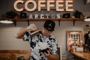 barista haciendo latte art detrás de la barra