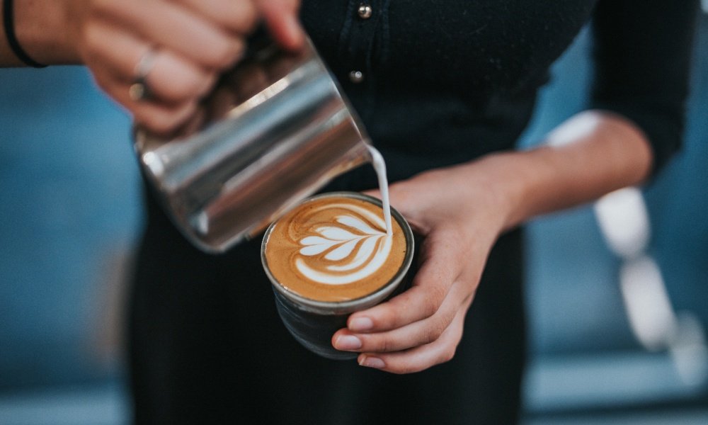 Barista vertiendo arte latte