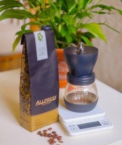 handgrinder, scale and a bag of coffee