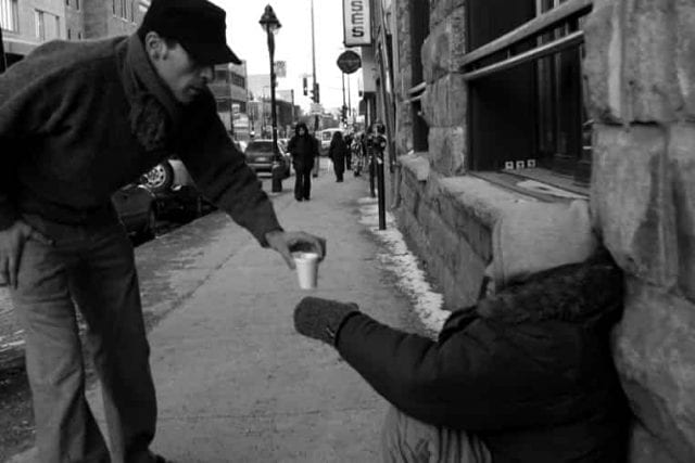 man giving coffee to homeless man