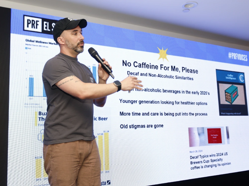 A person leads a lecture about demand for decaf coffee at PRF El Salvador.