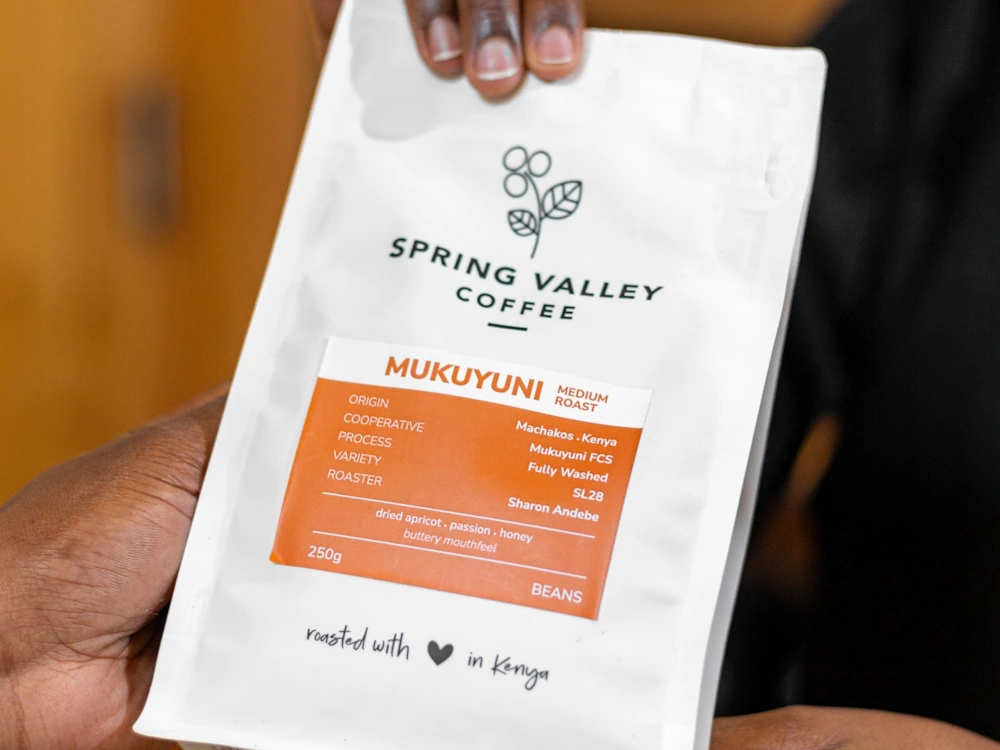 A person holding a Spring Valley coffee bag.